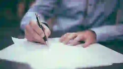 man signing a car title loan contract 501x282